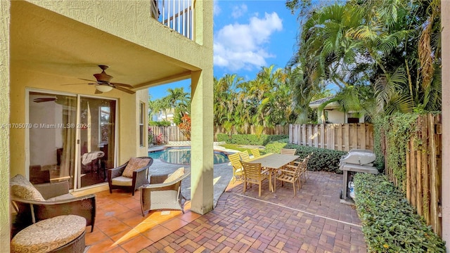 view of patio / terrace featuring grilling area, a fenced in pool, and ceiling fan