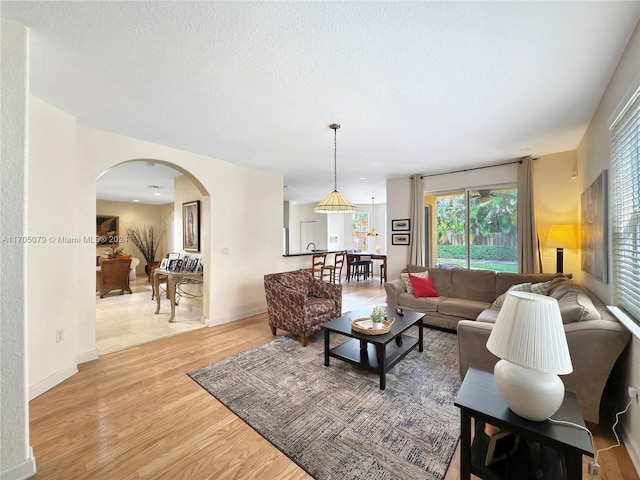 living room with a textured ceiling and light hardwood / wood-style flooring