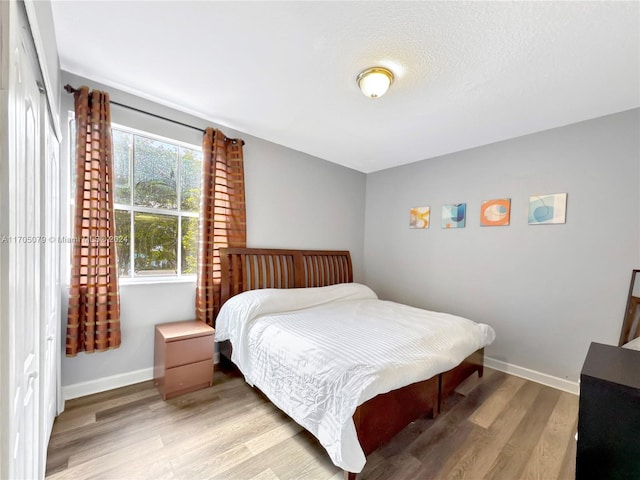 bedroom featuring hardwood / wood-style flooring and a textured ceiling