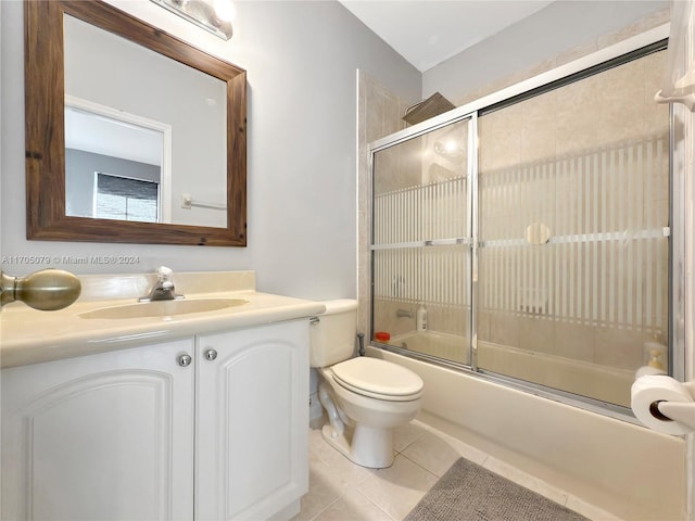 full bathroom with tile patterned floors, vanity, bath / shower combo with glass door, and toilet