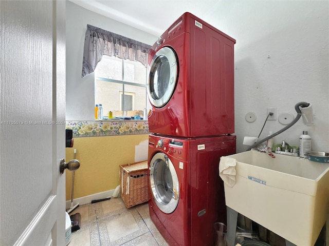 washroom with stacked washer / drying machine and sink