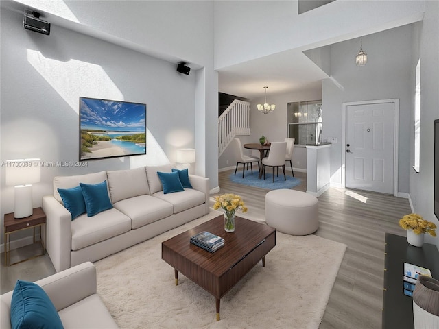 living room featuring a chandelier, wood-type flooring, and a towering ceiling