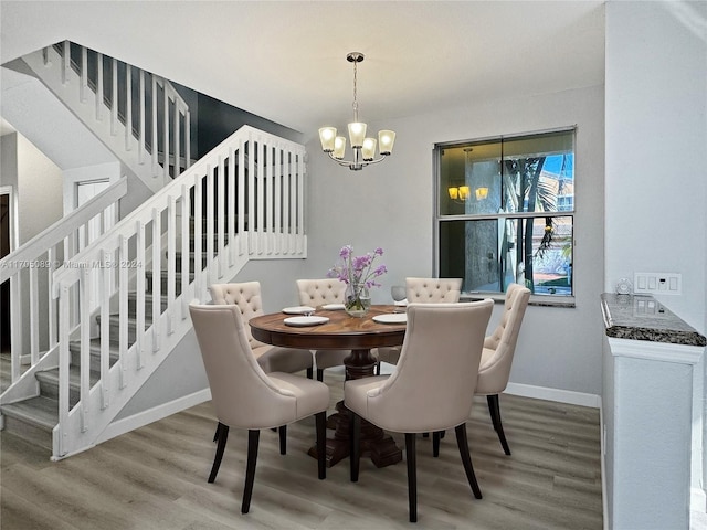 dining space featuring hardwood / wood-style flooring and a notable chandelier