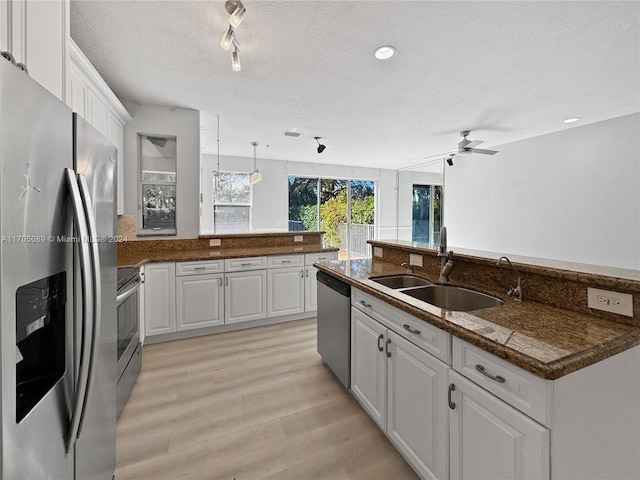 kitchen with white cabinetry, sink, stainless steel appliances, and light wood-type flooring