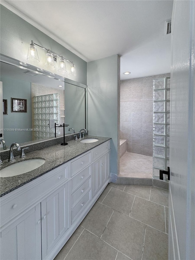 bathroom featuring tiled shower, vanity, and tile patterned floors