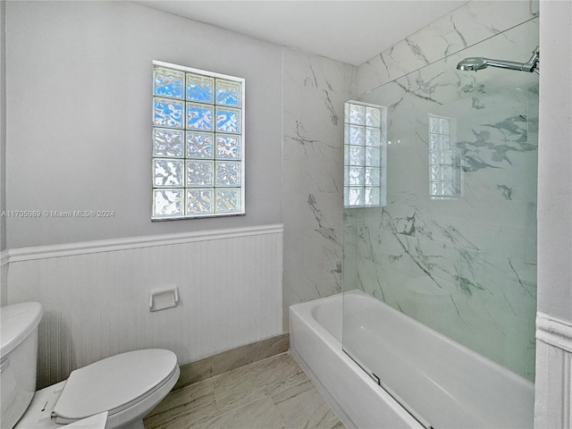 bathroom featuring toilet and tiled shower / bath