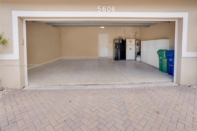 garage featuring black fridge with ice dispenser