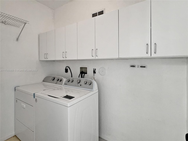 laundry area with washer and dryer and cabinets