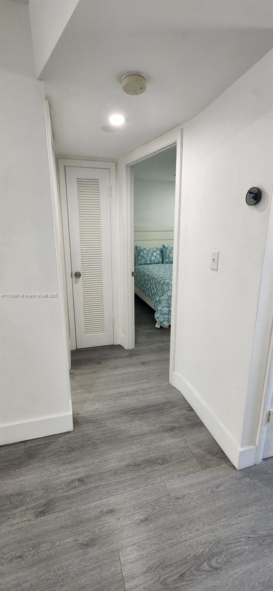 hallway featuring baseboards and wood finished floors