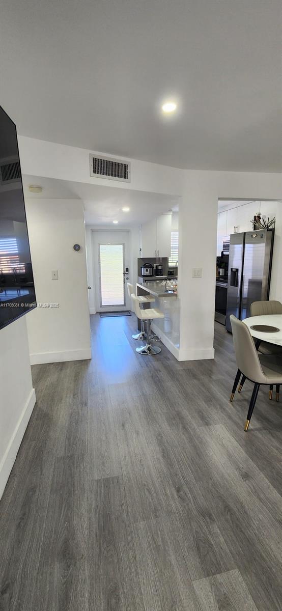 kitchen featuring white cabinetry, stainless steel refrigerator with ice dispenser, and dark wood-type flooring