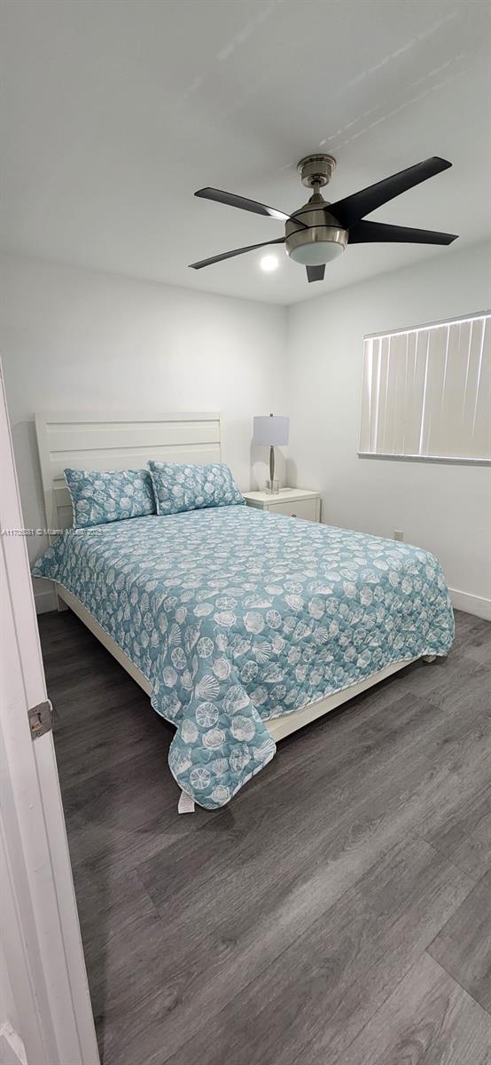 bedroom with dark hardwood / wood-style flooring and ceiling fan