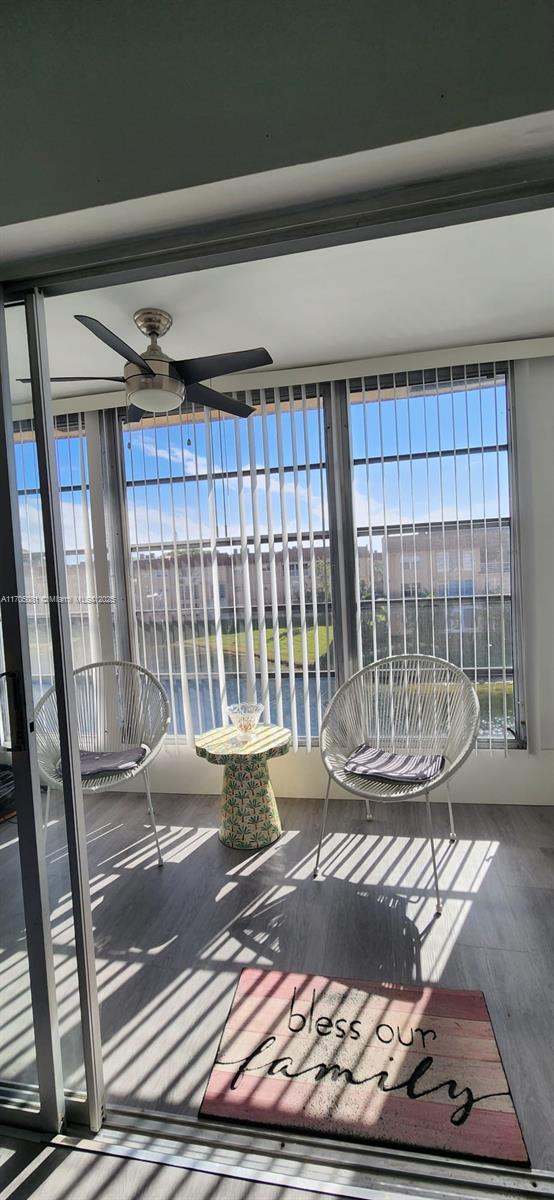 unfurnished sunroom featuring ceiling fan and plenty of natural light