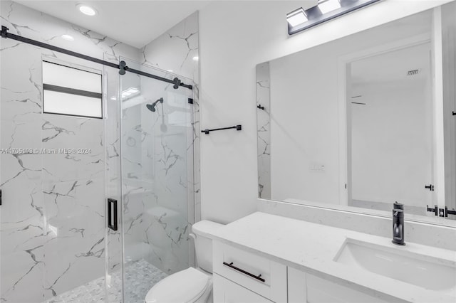 bathroom with vanity, toilet, and a shower with door