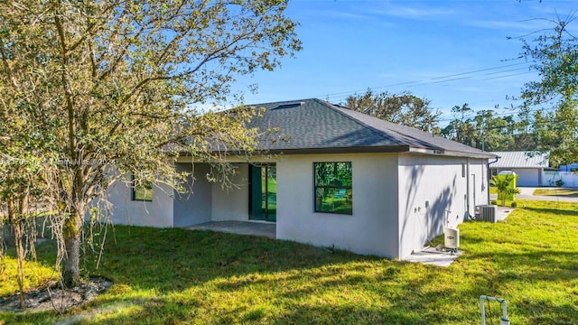 rear view of house with a lawn, central air condition unit, and a patio