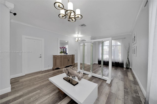 living room featuring wood-type flooring, a notable chandelier, and ornamental molding