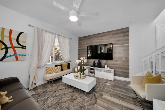 living room featuring wood walls, hardwood / wood-style floors, and ceiling fan