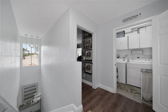 clothes washing area with separate washer and dryer, cabinets, and dark hardwood / wood-style floors