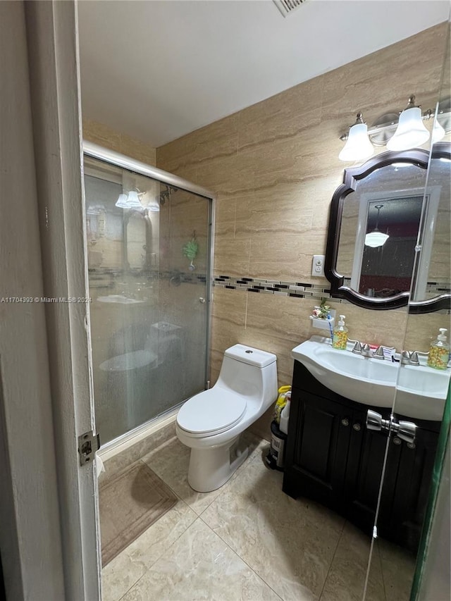 bathroom featuring a shower with door, vanity, and toilet