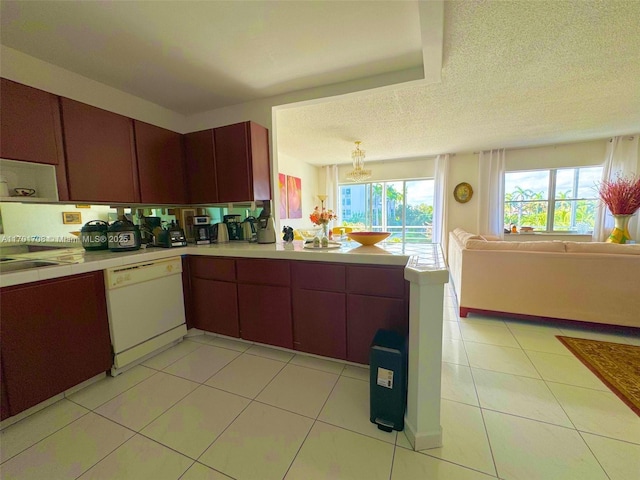 kitchen with a textured ceiling, light tile patterned floors, dishwasher, and kitchen peninsula