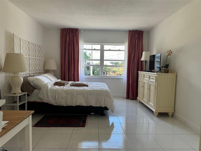 bedroom featuring light tile patterned flooring and a textured ceiling