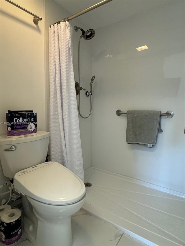 bathroom featuring curtained shower and toilet