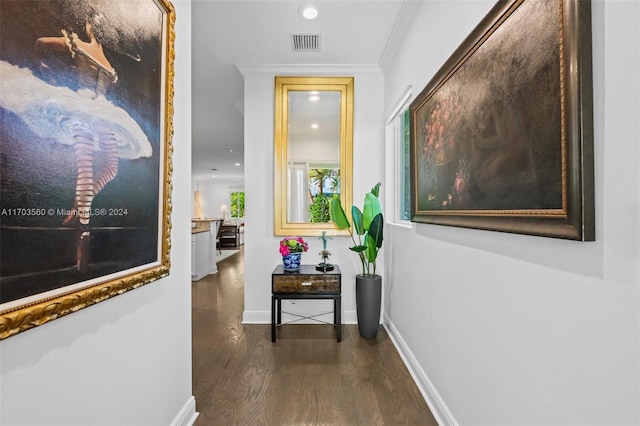 corridor with dark hardwood / wood-style flooring and ornamental molding