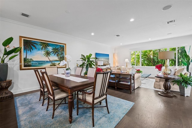 dining space featuring dark wood-type flooring and ornamental molding