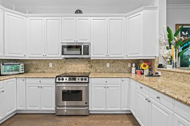 kitchen with decorative backsplash, white cabinetry, crown molding, and stainless steel appliances