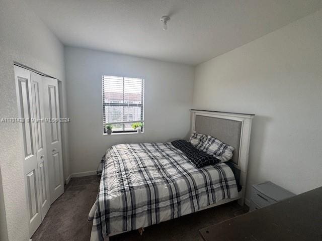 bedroom featuring dark carpet and a closet