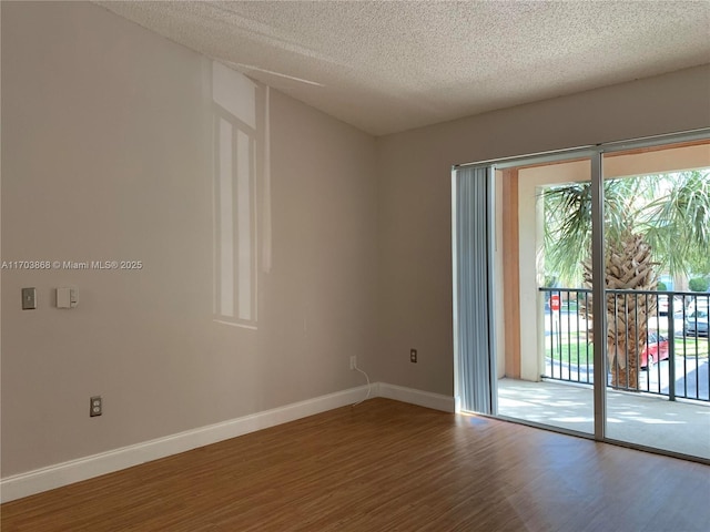 spare room featuring wood-type flooring and a textured ceiling