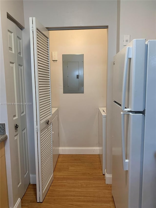 interior space with electric panel and light hardwood / wood-style flooring