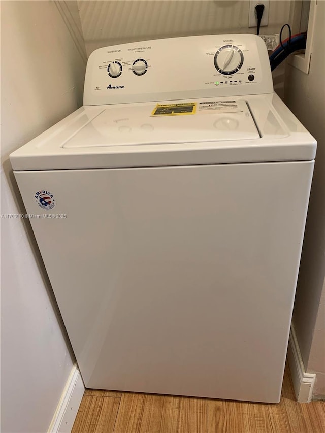 clothes washing area featuring light wood-type flooring and washer / clothes dryer