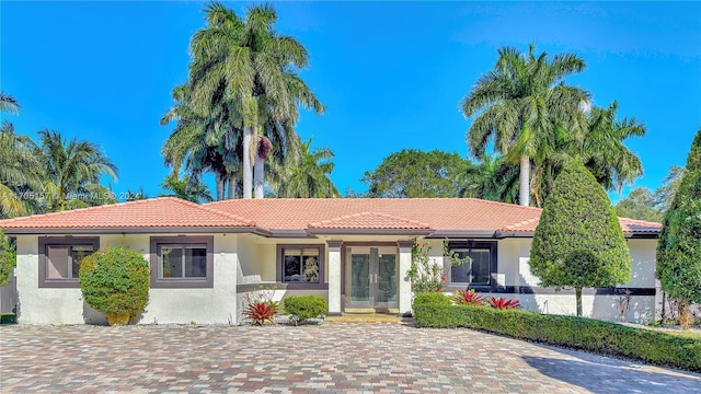 view of front of house featuring a tiled roof, french doors, and stucco siding