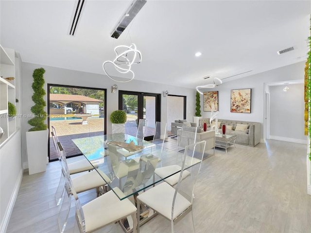 dining room featuring baseboards, visible vents, wood finished floors, and a notable chandelier