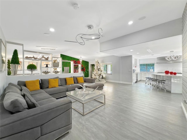 living area featuring baseboards, recessed lighting, and wood finished floors