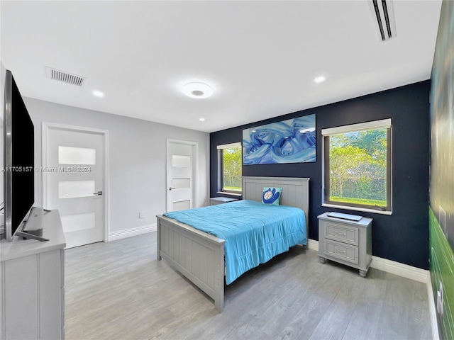 bedroom featuring light wood-style floors, baseboards, and visible vents