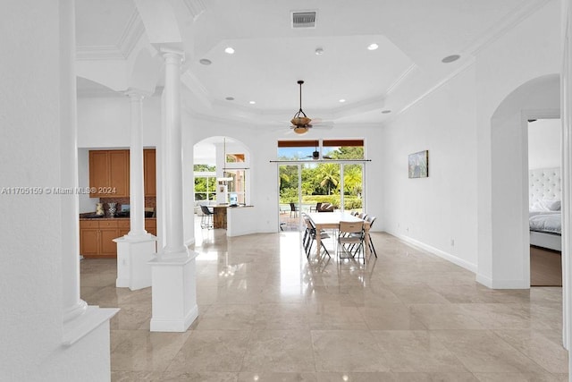 dining room featuring a tray ceiling, ornate columns, ceiling fan, and crown molding