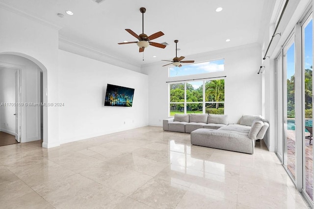 living room featuring a towering ceiling, ceiling fan, and ornamental molding