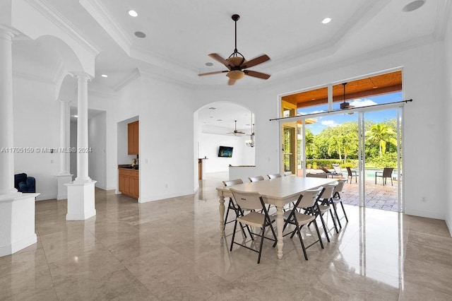 dining room with a tray ceiling, ceiling fan, decorative columns, and ornamental molding