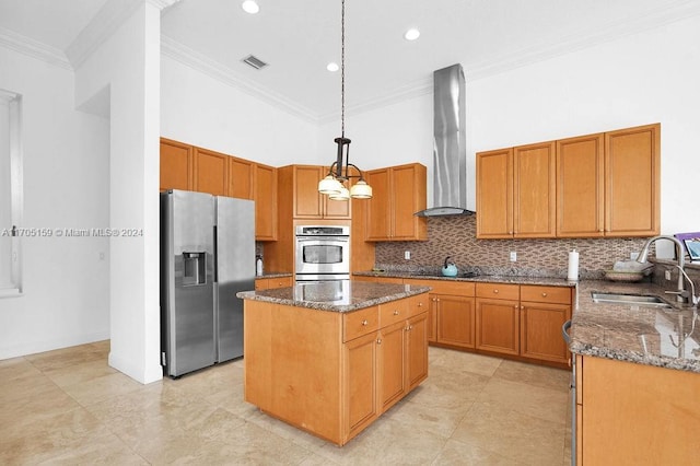 kitchen featuring a center island, sink, hanging light fixtures, wall chimney exhaust hood, and stainless steel appliances