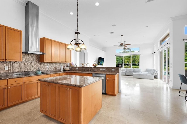 kitchen with sink, wall chimney range hood, dishwasher, a center island, and hanging light fixtures