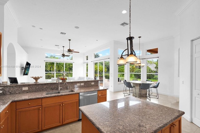 kitchen featuring ceiling fan, dishwasher, sink, an island with sink, and ornamental molding