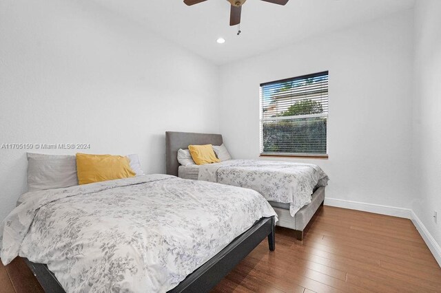 bedroom with dark hardwood / wood-style flooring and ceiling fan