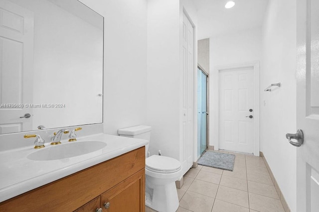 bathroom featuring tile patterned floors, vanity, an enclosed shower, and toilet