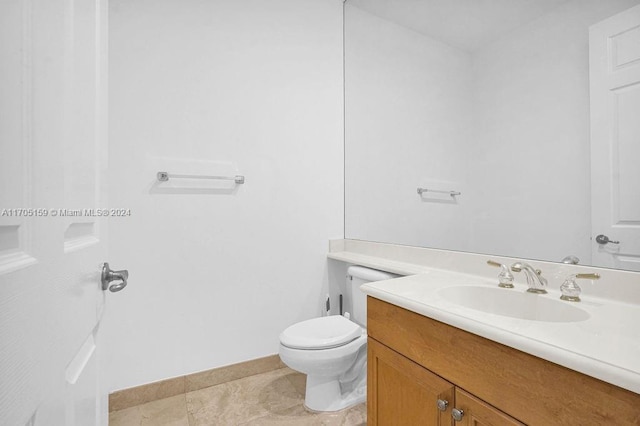 bathroom with tile patterned flooring, vanity, and toilet