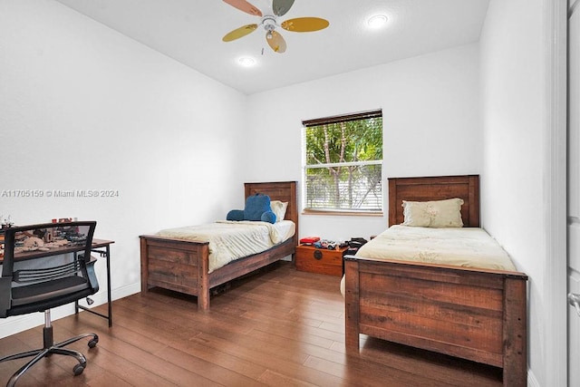 bedroom with ceiling fan, vaulted ceiling, and hardwood / wood-style flooring