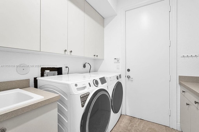 laundry area with cabinets, light tile patterned floors, and washing machine and dryer