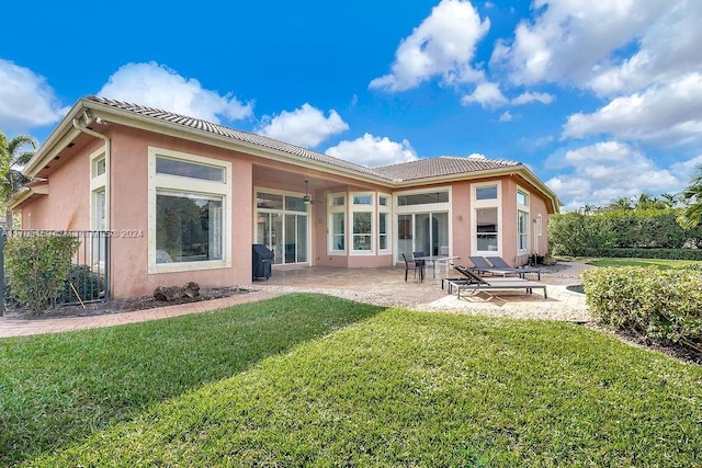 rear view of property with a patio area and a lawn