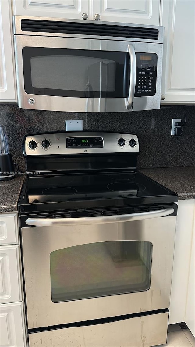 kitchen with decorative backsplash, white cabinetry, and appliances with stainless steel finishes