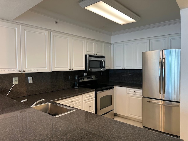 kitchen with white cabinets, backsplash, stainless steel appliances, and crown molding